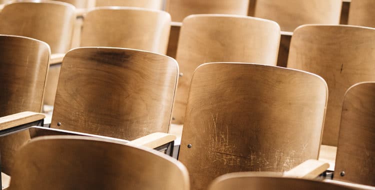 rows of wooden seats in an auditorium