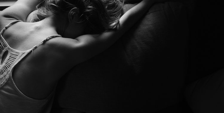 Grayscale photo of a drunk girl lying face down on couch