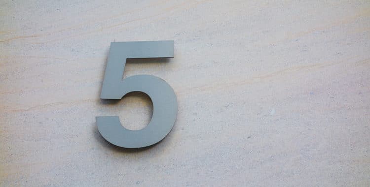 steel number five on a light beige marble wall