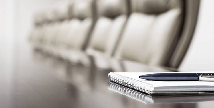 Close-up of pen atop a notepad kept on table in empty conference room