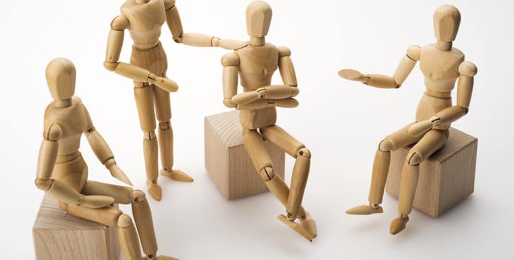 wooden dolls posed for group therapy session