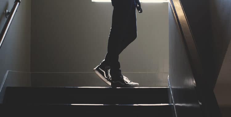 teenage boy turning corner of high school hallway stairs