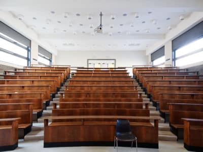 Empty classroom with one black chair in front