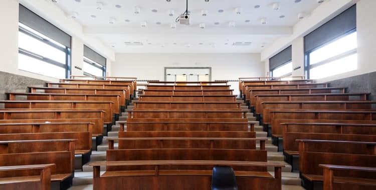 Empty classroom with one black chair in front